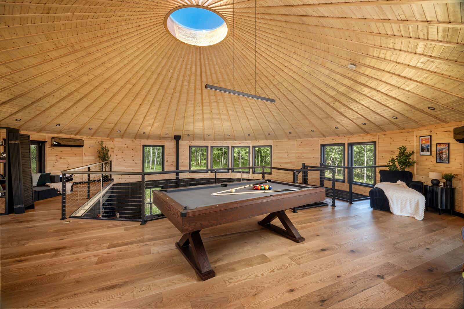 The loft level with a pool table, looking across the round room