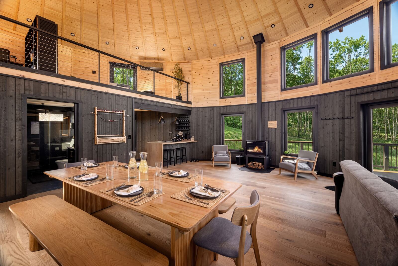 Dining table and wood stove against the 15 ft walls and factory-fitted windows